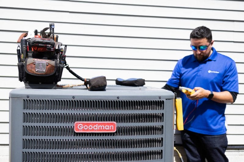 a a-c air care technician doing a heating maintenance and tune-up of a HVAC goodman brand in Elkridge, MD