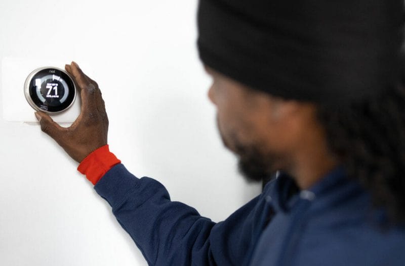 a technician checking the indoor air quality with thermostat